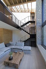 The wedge permeates the roof as well, creating a skylight right above the metal stairway that leads down to the living room, kitchen and dining room