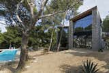 Both facades completely open up through large glazing surfaces to the view of the pines trees and the hills beyond