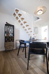 Dining Room, Chair, Table, Pendant Lighting, Medium Hardwood Floor, and Bar  Photo 12 of 15 in Fusion of Modern Minimalism and Family Heritage by Studio Bunyik
