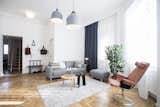 Living Room, Ottomans, Sofa, Coffee Tables, Pendant Lighting, Ceiling Lighting, and Light Hardwood Floor  Photo 4 of 15 in Fusion of Modern Minimalism and Family Heritage by Studio Bunyik