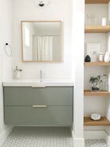 The guest bathroom utilizes a simple Ikea vanity custom painted to the perfect shade of green and features leather hardware from the Australian company Made Measure.