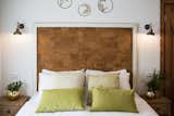 Bedroom, Bed, Wall Lighting, and Night Stands The headboard is made from cork board and painted wood  Photo 6 of 9 in A Crash Course on Cork: The Eco-Friendly Material That's Popping Up Everywhere from Golden apple guest rooms