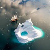 Sailboat creeping along the edge of an iceberg in Greenlands Sermilik Fjord  Photo 2 of 43 in 10 Travel Photographers to Follow on Instagram Right Now