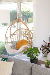 A hanging rattan chair is often used as a reading nook.&nbsp;