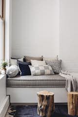 The built-in day bed by JFL Custom Builders provides a cozy corner. Topped with a pillow assortment by Walter G textiles, Bungalow Decor, and Injiri, it’s ideal for cuddling up with a book and a blanket. West Elm wood stumps and an antique hemp rug round out the space with some added depth.