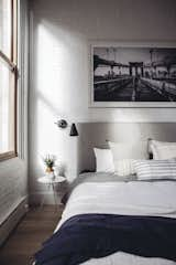 Exposed brick and natural light add a touch of quintessential New York loft  style to the updated home. Restoration Hardware sconces, pillows from Injiri and Susan Connor, and a throw from ABC home tie the room together in the perfect combination of structured and cozy. 