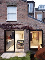 Amos Goldreich Architecture remodeled this terraced Victorian brownstone in Finsbury Park, London, for a couple with a newborn. The team reconfigured the ground floor by adding a side extension—clad in matching London stock brick—with an enlarged kitchen and efficient storage solutions. A large glass window with a built-in seating nook looks out to the garden.&nbsp;