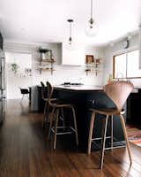 For the kitchen, Conklin did an almost full demolition, adding in new flooring, tearing out cabinets, and adding an island, subway tile, and open shelving. The couple turned to Rejuvenation for the pendant lights and All Modern for the chairs.
