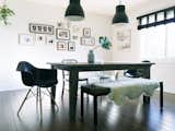 Reminiscent of Diane Keaton's inky abode, Conklin's moody dining room is furnished with Herman Miller chairs, IKEA pendant lights, and a Target bench.&nbsp;