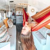Living Room, Bench, Ceiling Lighting, and Medium Hardwood Floor What's life on the road without a hammock?  Photo 6 of 18 in Love It or Hate It? Indoor Hammocks by Dwell from 10 Van-Lifers You Should Follow on Instagram Right Now