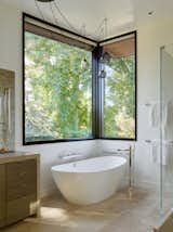 Bath, Stone, Ceiling, Freestanding, Enclosed, Drop In, Soaking, and Ceramic Tile A standalone soaking tub offers respite at the end of a long day.  Bath Enclosed Soaking Ceramic Tile Photos from A Silicon Valley Retreat Sports a Butterfly Roof and Two Indoor/Outdoor Wings
