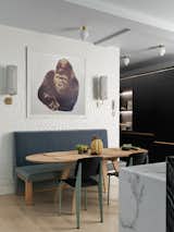 An Enzo Mari gorilla print hangs over the breakfast table, flanked by Erich Ginder fabric sconces. Overhead, a handful of Michael Anastassiades fixtures from The Future Perfect offers ample task lighting.