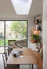 Inside the addition, the concrete floor was processed to expose the aggregate, mirroring the home’s exterior.&nbsp;A skylight over the dining table creates an inviting gathering space. Furniture was sourced from London’s Two Columbia Road.