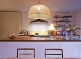 A bamboo pendant from Wonen Met Lef hangs over the kitchen island.