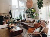 Living, Sofa, Standard Layout, End Tables, Dark Hardwood, Chair, Coffee Tables, and Ceiling Matt and Tish's family home is a modern bohemia.  Living Dark Hardwood End Tables Ceiling Photos from 9 Plant-Filled Abodes You Should Follow on Instagram Right Now