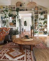 Living Room, Ceiling Lighting, Sofa, Medium Hardwood Floor, Sectional, and Coffee Tables Jaye Workman creates a rustic space with vintage finds.  Photos from 9 Plant-Filled Abodes You Should Follow on Instagram Right Now