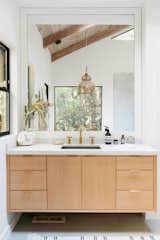 This bathroom features a custom-designed vanity with Kohler fixtures.