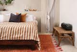 A rust-toned rug brightens up a bedroom.&nbsp;