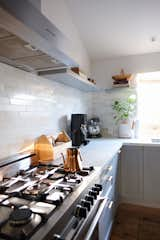 Kitchen, Ceramic Tile, Marble, Cooktops, Range Hood, and Medium Hardwood The couple’s day begins in the kitchen. Bryan has a ritual of making coffee for Danielle and tea for himself.   Kitchen Cooktops Marble Range Hood Ceramic Tile Photos from My House: How a Designer Couple Are Weathering the Pandemic in Their Berkeley Home