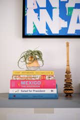 Their collection of cookbooks sits on a floating shelf in the kitchen alongside a molinillo from Mexico (a traditional whisk for hot chocolate). The print behind is from the Astrup Fearnley Museum of Modern Art in Oslo.