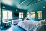 The primary bedroom is swathed floor-to-ceiling in a calming blue shade.