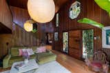 Frank Lloyd Wright–designed windows are installed in the living room, casting colored light across the space.