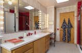 The main bathroom pairs rainbow-patterned wallpaper with fire engine red accents in a playfully bold aesthetic.&nbsp;