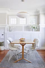 The dining area stands as a clean palette ready for everything from dinner with the family to hosting a gathering over a Houzz Dining table and Eames chairs from Design Within Reach. Overhead a Nelson Saucer Pendant Light illuminates the space, while a vintage rug from Etsy adds a cozy touch.  “Our dining room built-ins used to have nothing but tiny, rickety drawers, so we hollowed it out and replaced the drawers with deep shelves that we use to store everything from platters to art to office supplies.”