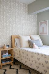 A simple Pottery Barn bed and nightstand set allow for tons of pattern in Emilie's room via This Little Street removable wallpaper, Erica Tanov bedding, and a Moroccan-style rug. Accents are kept minimal like the very practical Schoolhouse studio clock and framed art from Printable.