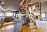 This custom spiral wood staircase comes from the mind of architect Fred Babcock. His redesign of this modern log cabin in Salt Lake City, Utah, contributes to the home’s bright interior without blocking any natural light. The stairs’ organic light-toned wood blends beautifully with the cabin’s interior colors, flooring, and stonework.&nbsp;