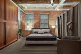 Take a page from the design of this former Tetley Tea Warehouse turned residence. The home features the building’s original concrete columns, beams, and exposed brick for an authentic hard-loft feel, and the modern lighting blends seamlessly with the style. Exposed globe bulbs offer the bedroom a retro, industrial aesthetic, with enhanced lighting from the bedside lamps.