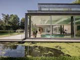 A  Contemporary Villa in Belgium Comes Complete With a Landscape Pond and Showroom Garage