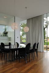 Dining Room, Table, Medium Hardwood Floor, Chair, Lamps, Ceiling Lighting, Recessed Lighting, and Pendant Lighting The dining room  Photo 11 of 17 in White Snake house by AUM Pierre Minassian