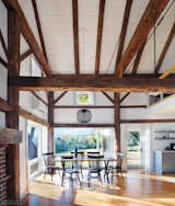 Robert Swinburne chose to leave some of the barn's original elements, such as the rustic timber frames. The dining, kitchen, and living areas are now filled with light.