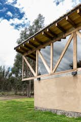 The wooden beams rests on the rammed earth walls, generating a framework every 70 cm for the roof. The upper closures of the construction are glass, allowing to have a zenithal and indirect light in the house.
The social area opens from end to end towards the land through access platforms; in the front generates a vestibule and in the back a covered deck with a fire pit.