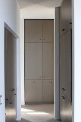 Custom cabinets line the hallway and dressing room of the private master suite.