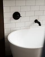 A free standing soaking tub is located in the master bath wet room.