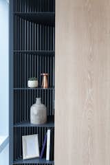The custom-made cabinet wall with white washed oak panels and charcoal grey metal detail, resting in front of a striped backdrop. #studioadjective @studioadjective #apartment #home