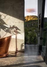 A bespoke copper bathtub and matching tapware is framed by expansive mountainside views.