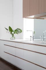 Kitchen, Quartzite, White, Wood, Light Hardwood, Mirror, Recessed, Undermount, and Medium Hardwood Mirrored backsplash deflects light from the opposite window and softens a typically, hard, utilitarian surface.  Kitchen Quartzite Wood Mirror Photos from Coach House