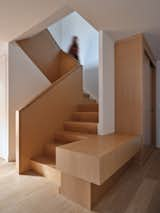 Staircase, Wood Railing, and Wood Tread At the entry: a sculpted white oak closet and bench integrate with the white oak stair—a single element that leads one into the space and up to the second level.  Photo 4 of 11 in Hazel Flat by Barbora Vokac Taylor Architect