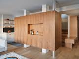 The walnut storage cabinet both divides and connects the main spaces.