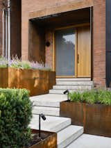 The front walkway is integrated with the landscape design for a more private approach. The steel elements, weathering over time, sit in contrast with the blackened metal details at the interior.