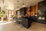 The kitchen pairs an off-the-shelf IKEA island and cabinetry with high-end appliances, vintage pendant lights and black soapstone counters. The smooth cedar backsplash warms the space.