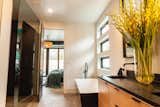 The master bath serves as an oasis and retreat after a busy day. A floating cedar vanity topped with black soapstone and a large soaking tub complete the escape.