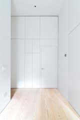 Custom White Lacquer Panels and White Ash Flooring Hallway Storage