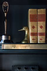 Bookshelf detail - a Clio award sits next to vintage books, brass detail bookshelf corner element