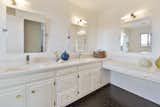 Updated master bathroom with Japanese porcelain tiled floor, painted cabinets, quartz counter with under-mount sinks and Rejuvenation cabinet pulls.