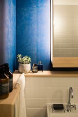 Lacquered wallpapers bring a vibrancy of colour to the bathroom.