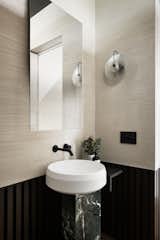 The powder room features a marble pedestal basin from Agape and hand troweled clay walls.